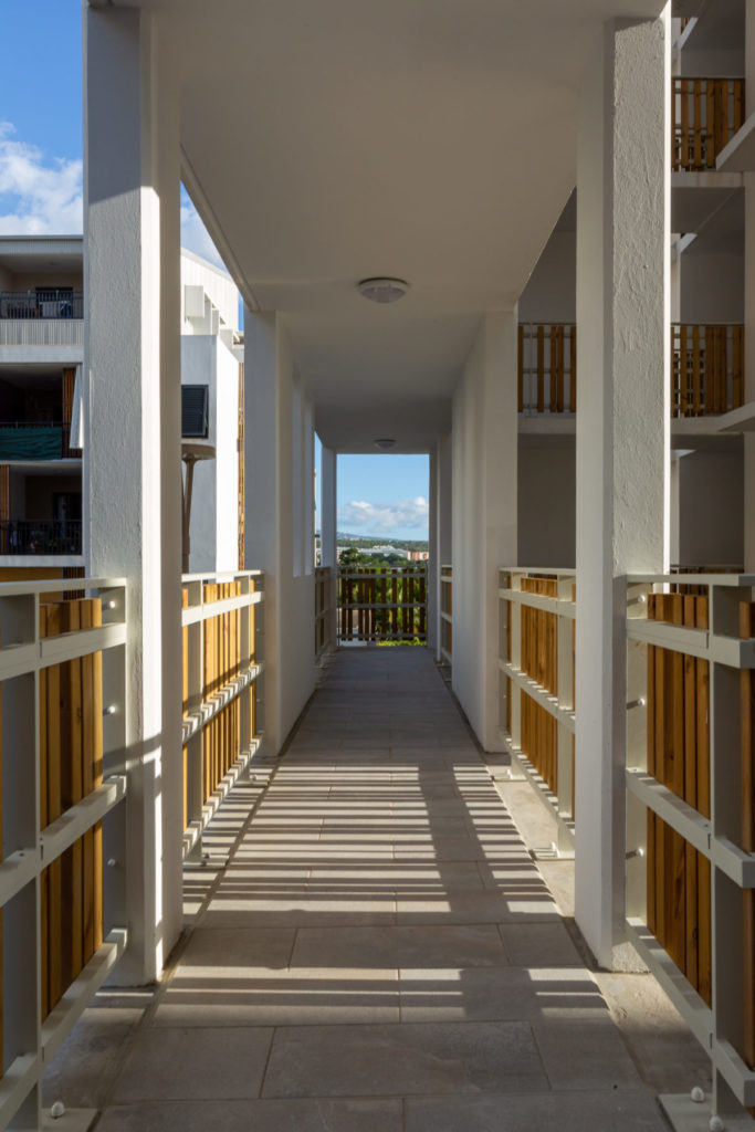 Photographie en couleur d'une coursive d'un bâtiment de logements collectifs