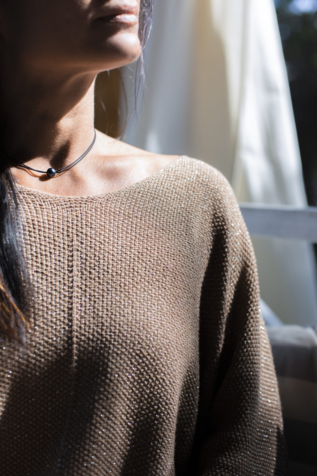 Photo couleur d'un femme portant un collier avec une perle noire