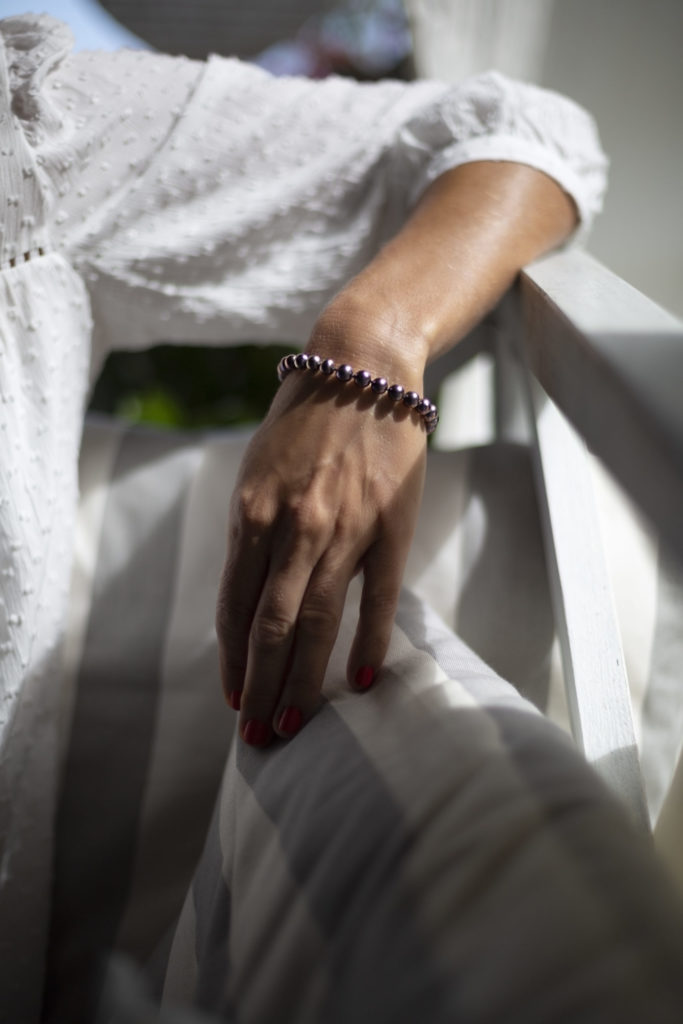 Photo couleur d'une main de femme portant un bracelet de perles de culture noires