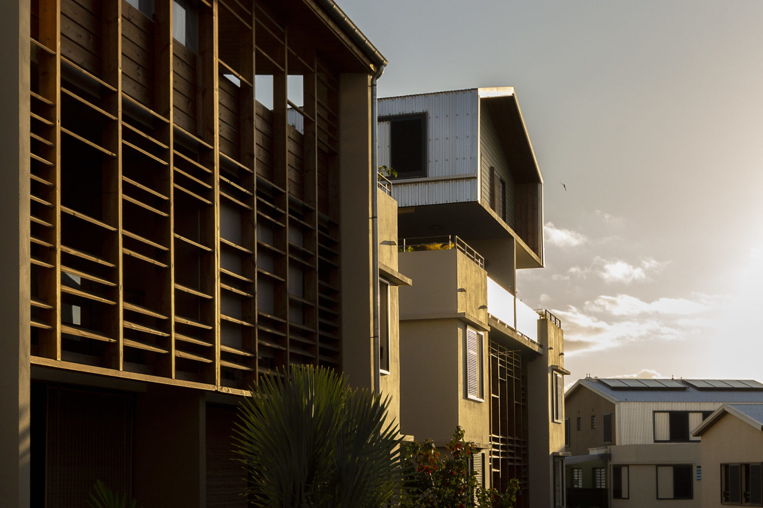 Photographies couleur de façades de logements sociaux au couché de soleil.